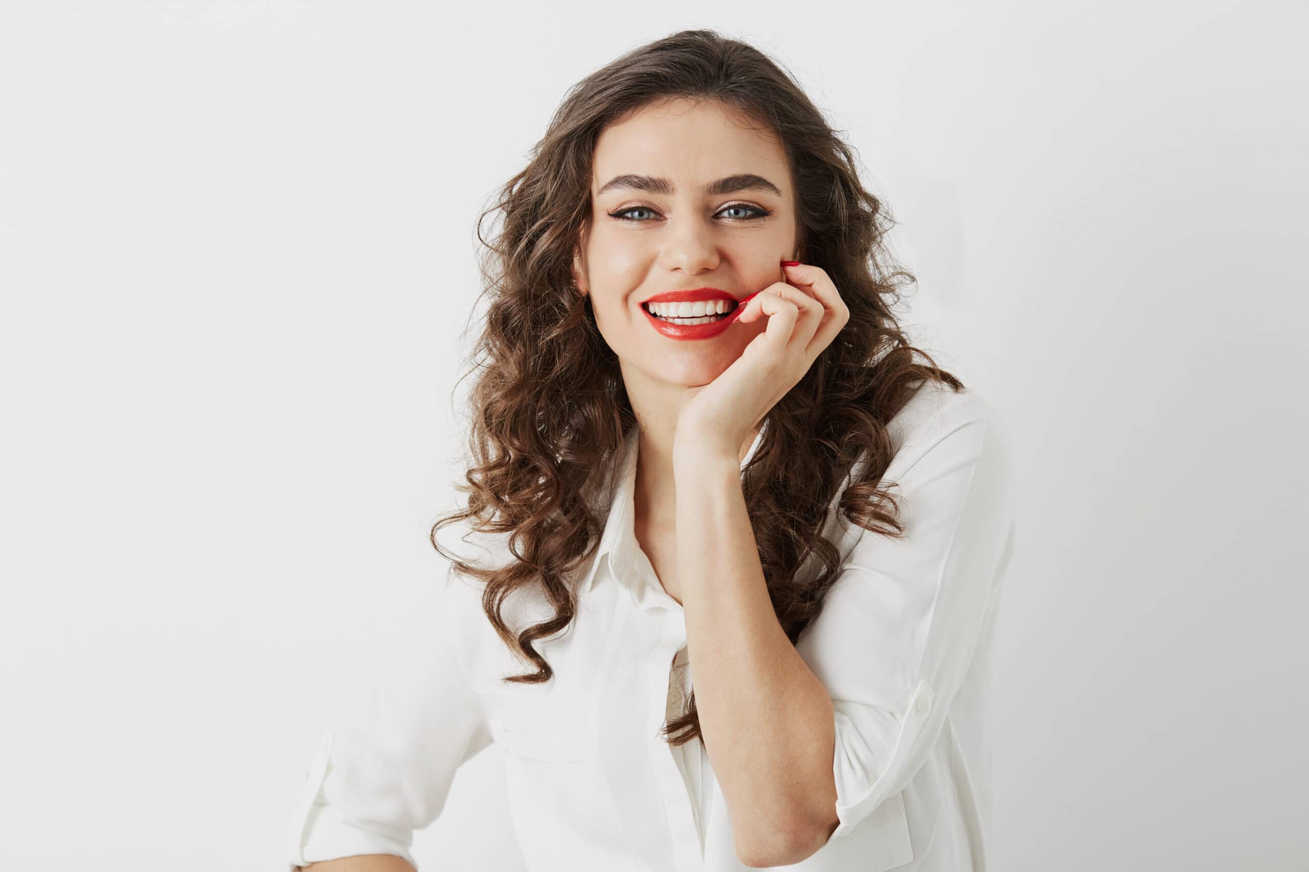 close up portrait of candid smiling attractive woman with white teeth looking in camera isolated, long curly hair, white blouse, elegant business style, happy positive emotion, red lipstick make-up